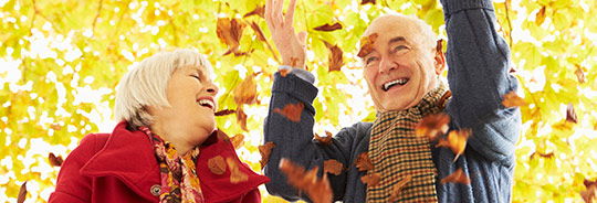 photo of couple standing in fall leaves