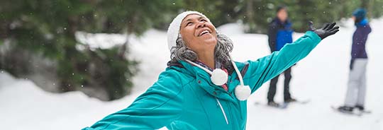 senior-woman-snowshoeing-in-the-forest-with-her